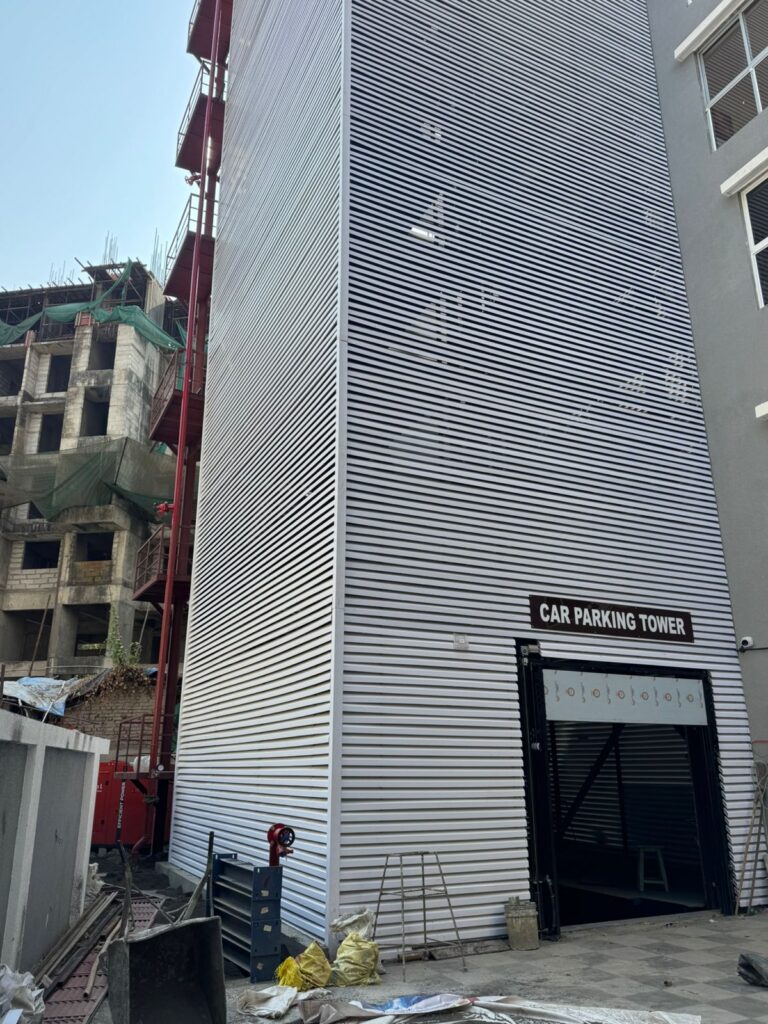 Corner view of the Upvc fin-clad car parking tower against the under-construction site backdrop, Bhandup