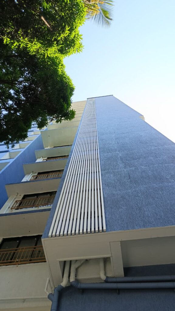 Vertical white Upvc fin duct screen against the blue façade, Bhaveshawar Heights, Dahisar